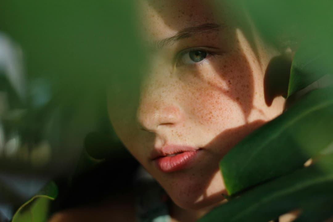 Close-up Photo of Woman Hiding Behind Green Leaves Close-up Photo of Woman Hiding Behind Green Leaves