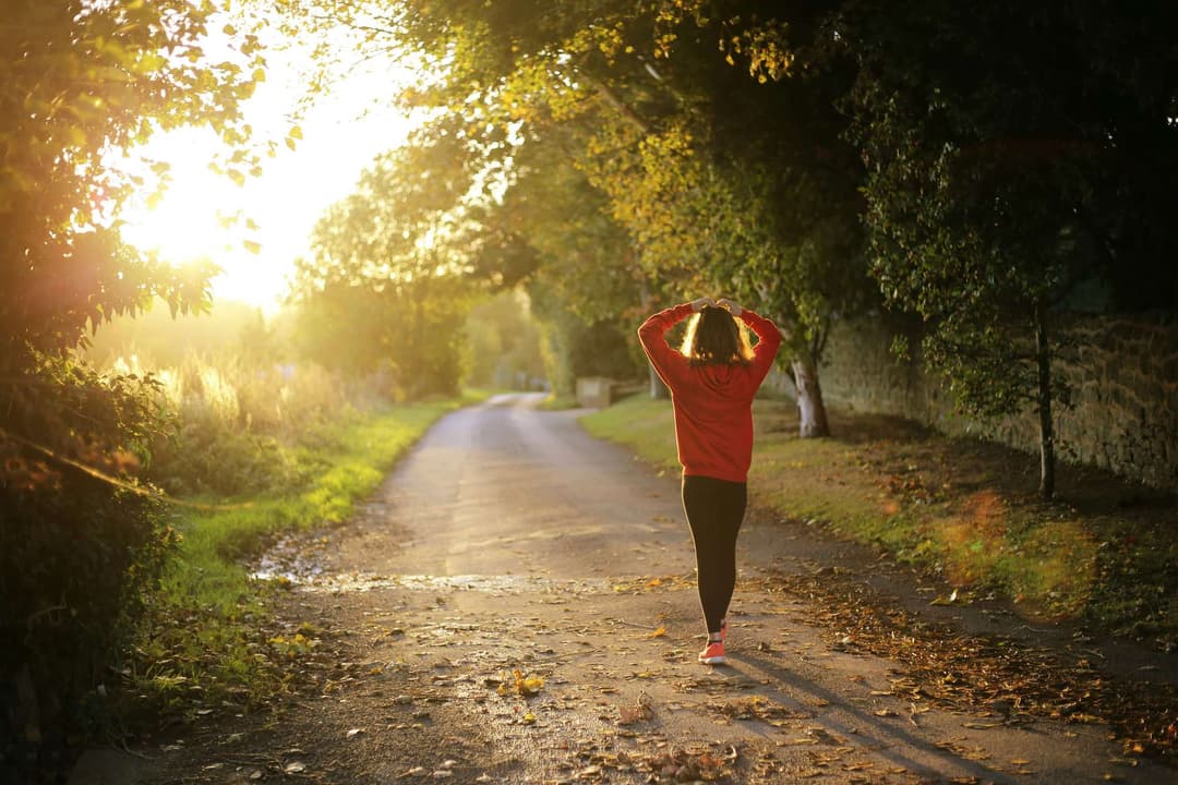 Woman walking on pathway during daytime Woman walking on pathway during daytime